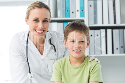 Friendly doctor with boy in clinic