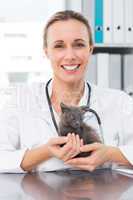 Happy female vet holding kitten