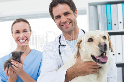 Confident veterinarians with dog and kitten