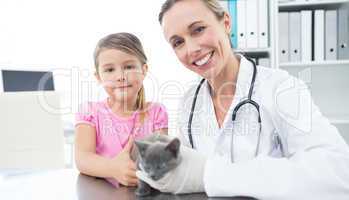 Vet and girl with kitten in clinic