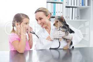 Vet with girl examining puppy