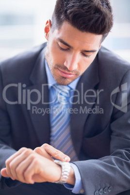 Businessman sitting checking his watch