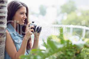 Pretty young girl taking photographs outside