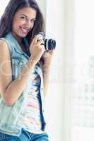 Stylish young woman taking a photo smiling at camera