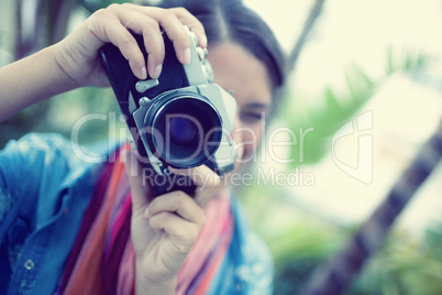 Brunette taking a photo outside looking at camera