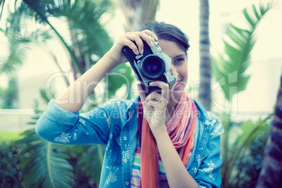 Smiling brunette taking a photo outside