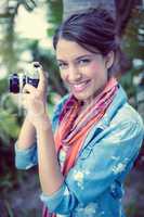 Cheerful brunette taking a photo outside smiling at camera