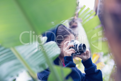 Young woman taking a picture in a forest