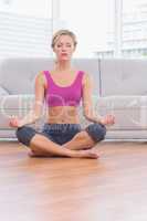 Fit blonde meditating in lotus pose