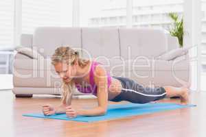 Fit blonde in plank position on exercise mat