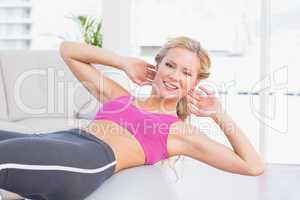 Happy fit blonde doing sit ups with exercise ball