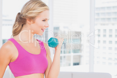 Pretty blonde lifting dumbbells and smiling