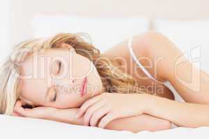 Natural young blonde lying on her bed asleep