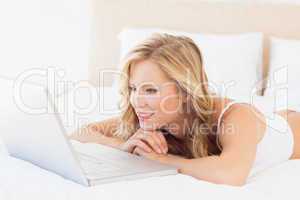 Cute young blonde watching her laptop