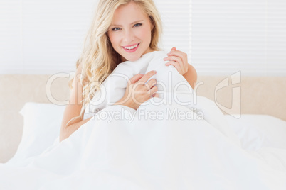 Sexy blonde covering herself with duvet