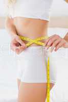 Toned woman measuring her waist