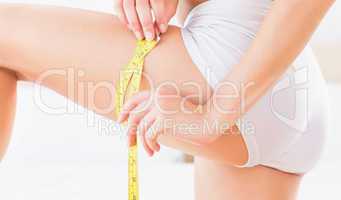 Toned woman measuring her thigh