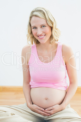 Glowing pregnant blonde smiling at camera