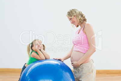 Smiling pregnant woman with young daughter