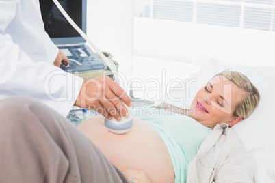 Smiling pregnant woman having a sonagram scan