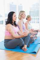 Meditating pregnant women in yoga class
