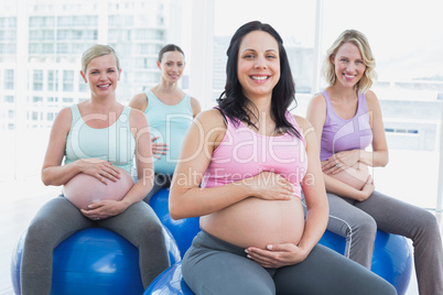 Smiling pregnant women sitting on exercise balls