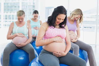 Cheerful pregnant women sitting on exercise balls