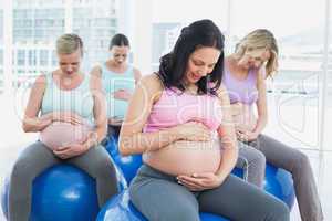Cheerful pregnant women sitting on exercise balls