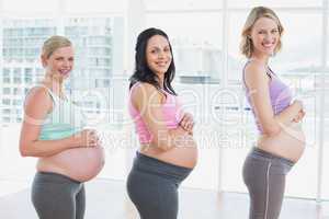 Pregnant women standing in a line smiling at camera