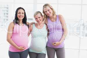 Pregnant women standing smiling at camera