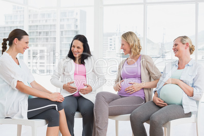 Happy pregnant women talking together at antenatal class