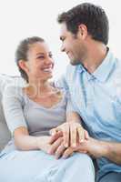 Excited couple looking at each other on the couch