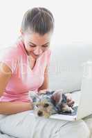 Pretty woman using laptop with her yorkshire terrier