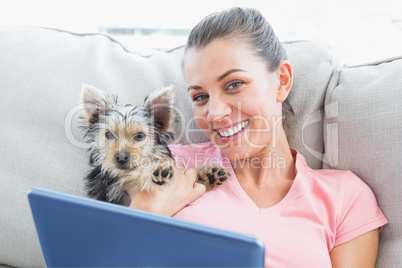 Attractive woman using tablet pc with her yorkshire terrier