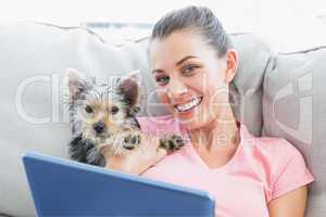 Attractive woman using tablet pc with her yorkshire terrier