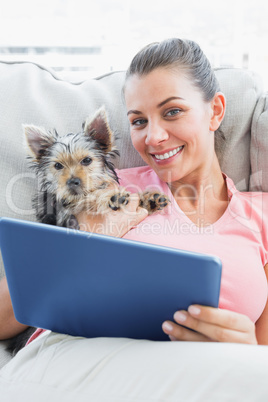 Attractive woman using tablet pc with her yorkshire terrier