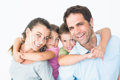Smiling young family looking at camera together Smiling young family looking at camera together