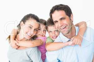 Smiling young family looking at camera together