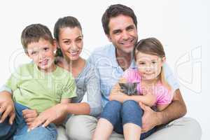 Cute family with pet kitten posing and smiling at camera togethe