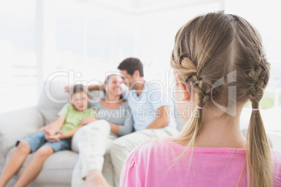 Little girl watching her family on the couch