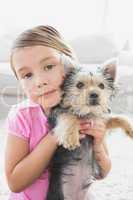 Little girl holding her yorkshire terrier puppy