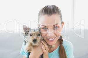 Smiling woman holding her yorkshire terrier puppy