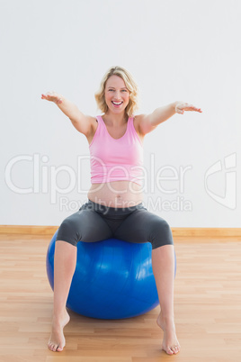 Pretty pregnant woman sitting on exercise ball