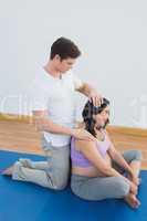 Masseur massaging pregnant womans shoulder and neck