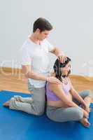 Masseur massaging pregnant womans head and neck