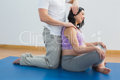 Masseur manipulating pregnant womans head and neck