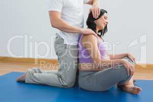 Masseur manipulating pregnant womans head and neck