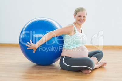 Happy pregnant woman sitting beside exercise ball Happy pregnant woman sitting beside exercise ball