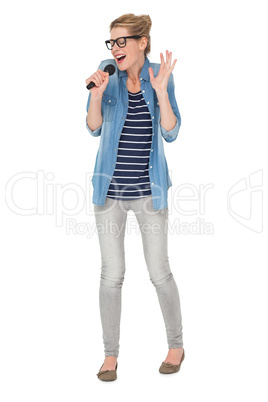 Full length of a young woman singing into a microphone