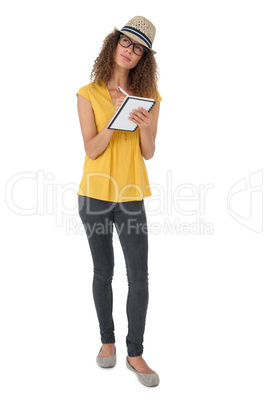 Thoughtful cool young woman writing in notepad